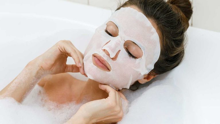 Femme se détendant dans la baignoire avec le masque tissu Chill Out